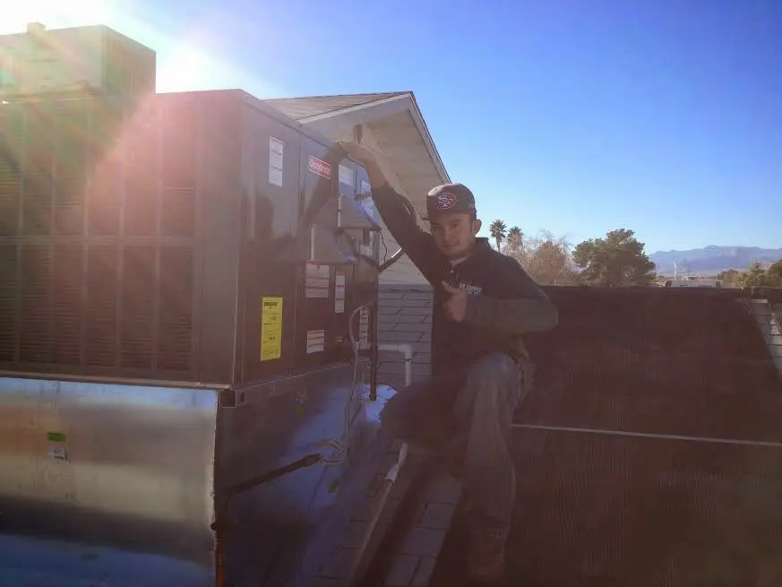 HVAC technician performing Air Duct Cleaning on a rooftop unit in Cudahy