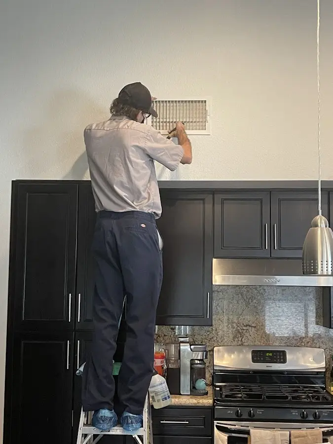 Technician inspecting an air vent during HVAC service in Cudahy